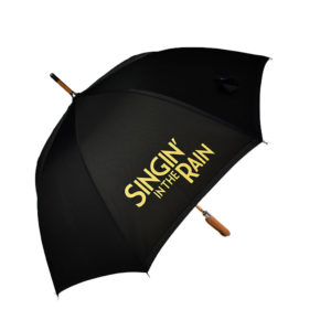 Black umbrella with Singing In the Rain printed in yellow on one umbrella panel