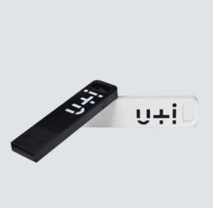 two slim rectangular USBs lying on a grey background. One is white and one is black and both have reversed colour logo that is U+I