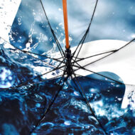 water splash print on inside panel of umbrella with black ribs and wooden pole